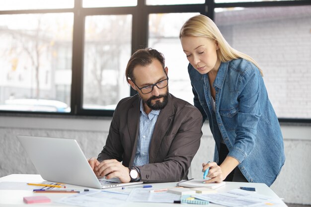 Free photo happy blonde female manager has conversation with male colleague