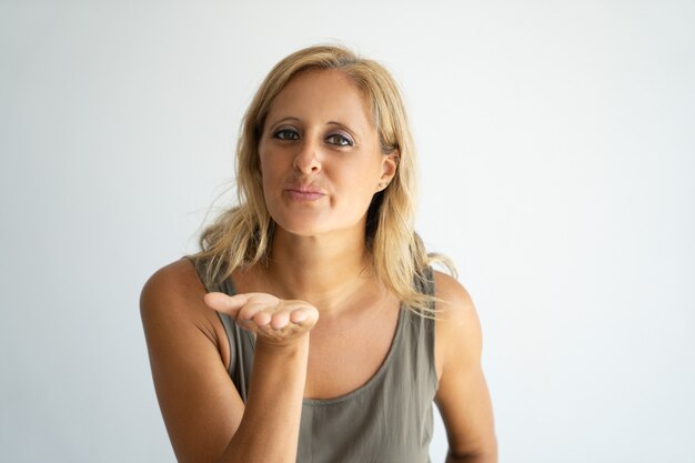 Happy blonde lady expressing love by gesture. 