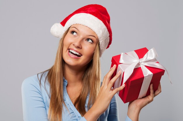 Happy blonde woman holding small red gift