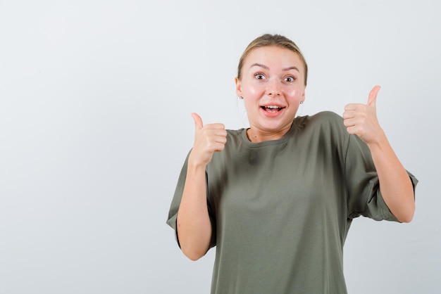 The happy blonde woman is showing perfect gesture with thumbs  on white background