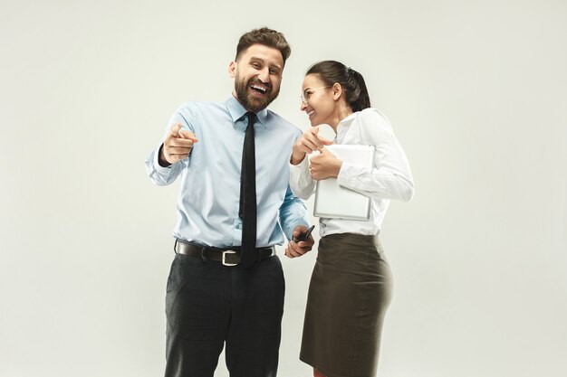 Happy boss. Man and his secretary standing at office