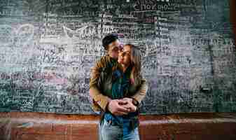 Free photo happy boy embracing and kissing his girlfriend