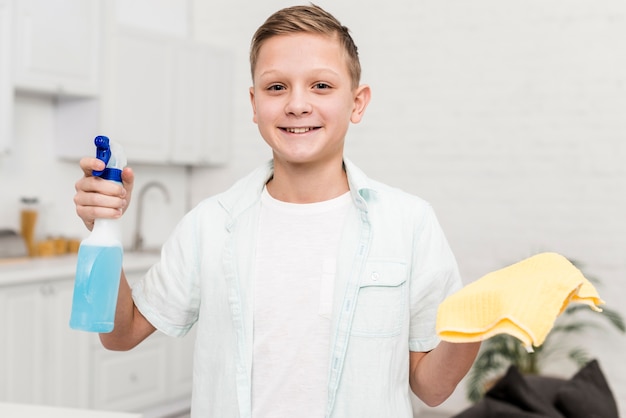 Happy boy holding cleaning product