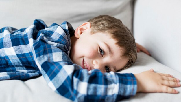 Happy boy at home laying on the sofa