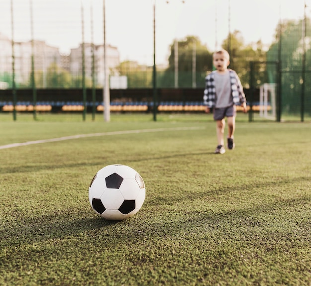 屋外でサッカーをしている幸せな少年