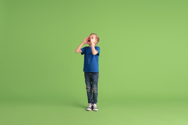 Happy boy playing and having fun on green wall emotions