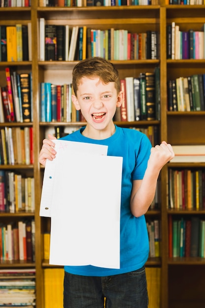 Happy boy showing paper with excellent mark 