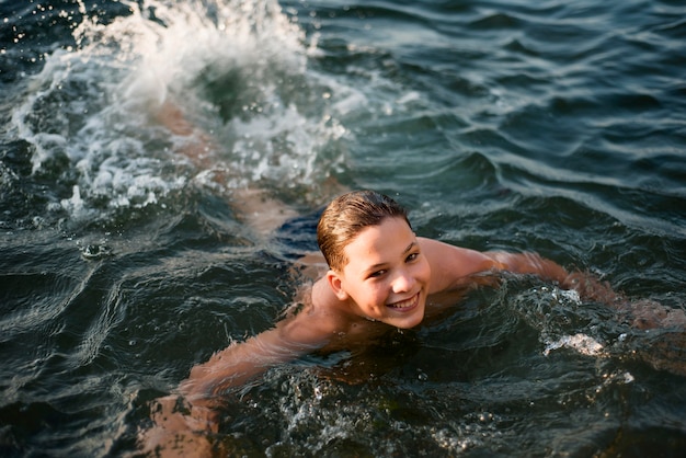 바다에서 수영하는 행복 한 소년