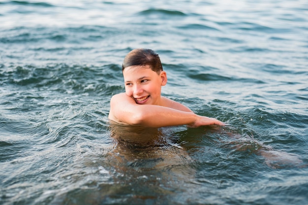 海で泳いでいる幸せな少年