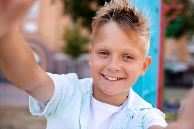 遊び場でselfieを取って幸せな少年