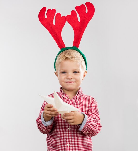 Happy boy with tree star and reindeer antlers