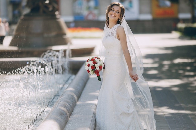 Happy bride close to the fountain