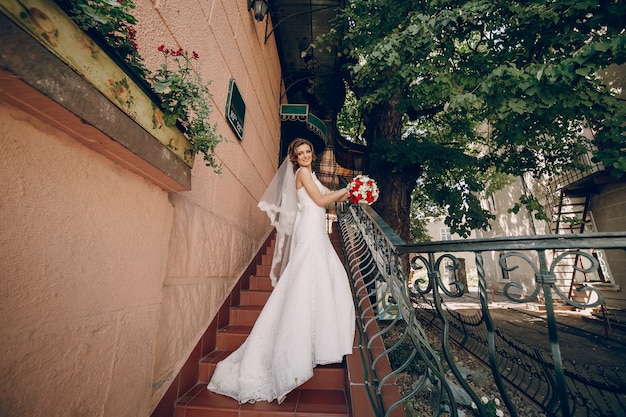 Happy bride posing on stairs
