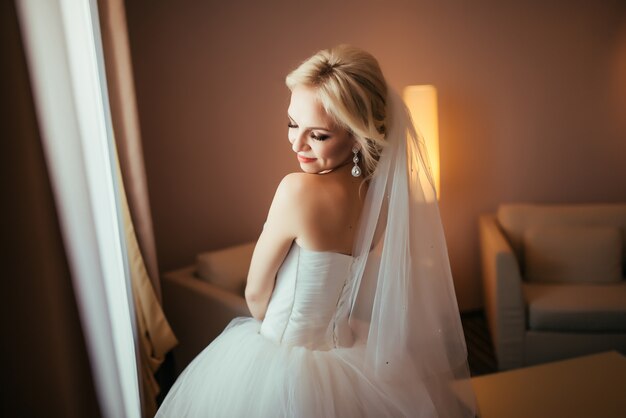 Happy bride standing with closed eyes, getting pleasure from future wedding. 