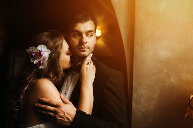 Happy bride with face on groom's neck