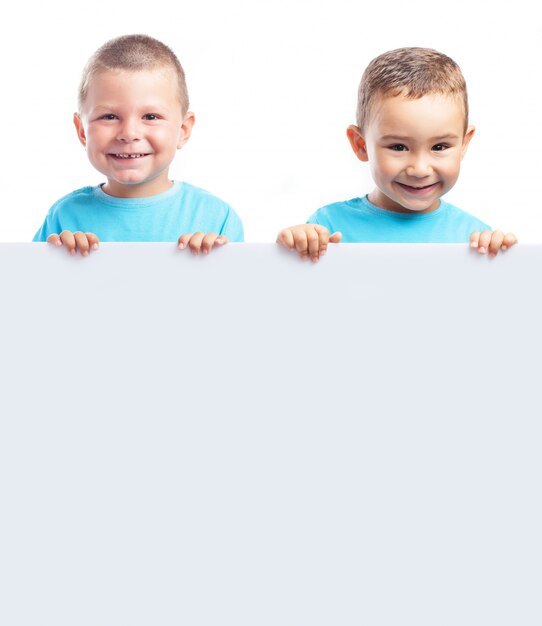 Happy brothers showing an empty signboard