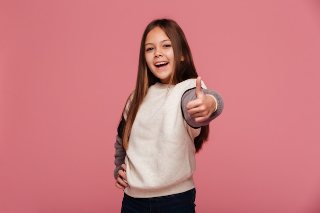 Foto gratuita ragazza felice del brunette che mostra i pollici in su e sorridere