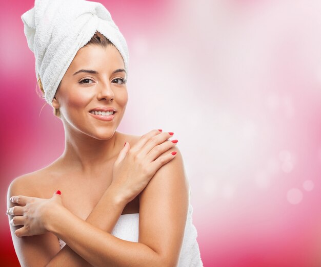 Happy brunette in towel on hair embracing herself