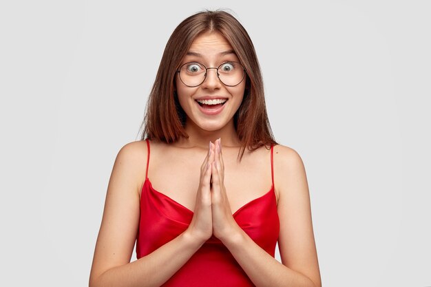 Happy brunette young woman posing against the white wall