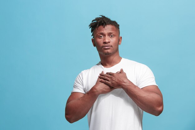 The happy business afro-american man standing and smiling against blue background.