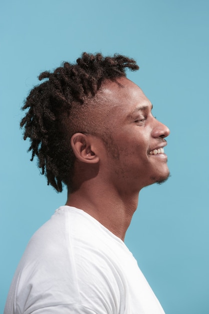 Счастливый бизнес афро-американский мужчина, стоящий и улыбающийся на синем фоне.