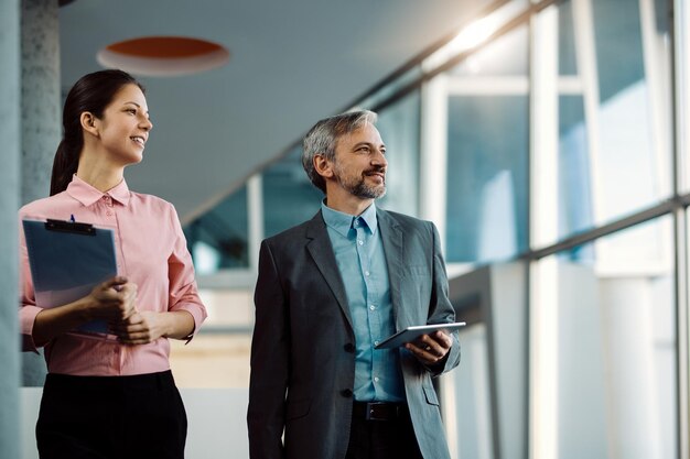 Happy business coworkers walking through a hallway of an office building