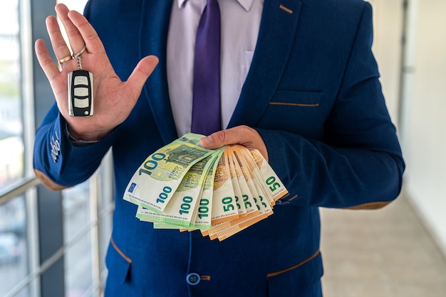 Happy business man holding car keys with euro money in office finance concept Premium Photo
