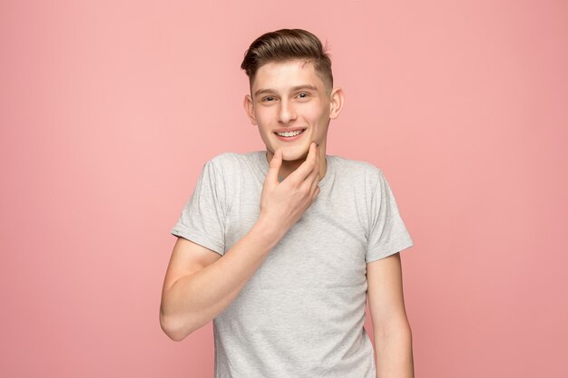 The happy business man standing and smiling against pink wall.