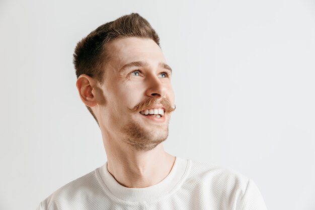 Happy business man standing, smiling isolated on gray studio background. Beautiful male half-length portrait. Young satisfy man. Human emotions, facial expression concept.