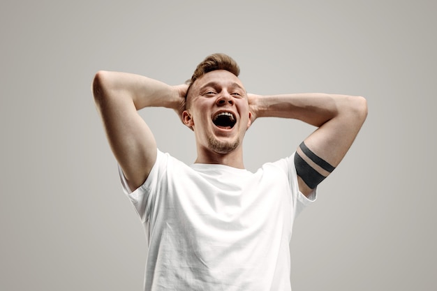 Happy business man standing, smiling isolated on gray studio background. Beautiful male half-length portrait. Young satisfy man. Human emotions, facial expression concept.