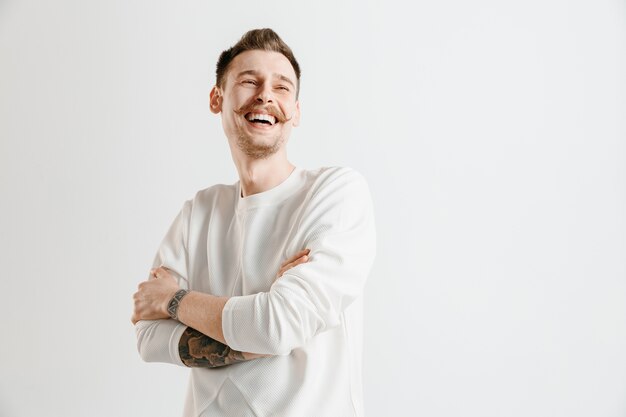 Happy business man standing, smiling isolated on gray studio background. Beautiful male half-length portrait. Young satisfy man. Human emotions, facial expression concept.