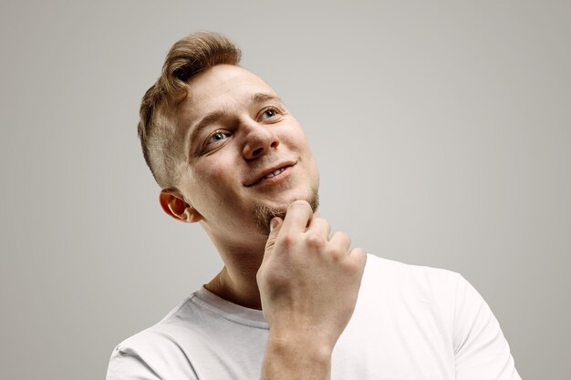 Happy business man standing, smiling isolated on gray studio wall