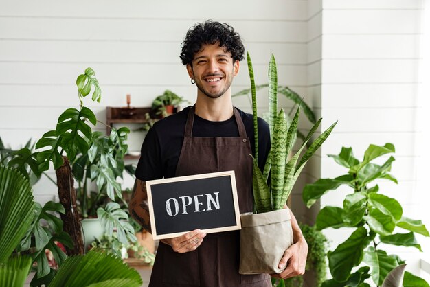 Happy business owner holding we are open sign