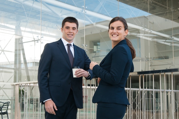 Happy business people drinking coffee and posing outdoors