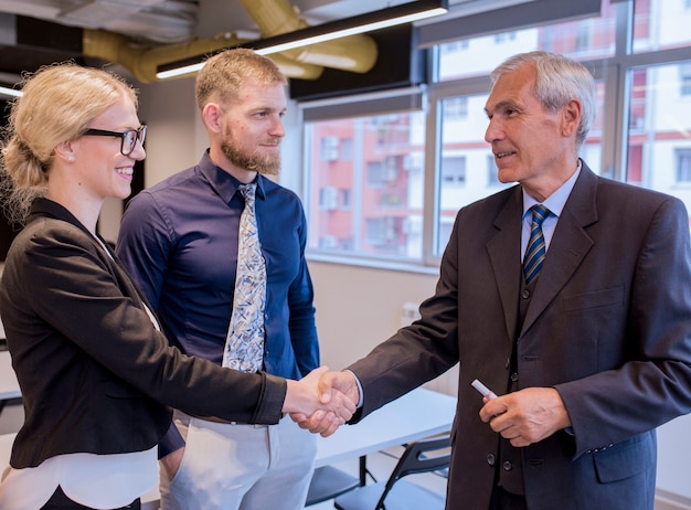 Happy business people shaking hands after finishing up a meeting