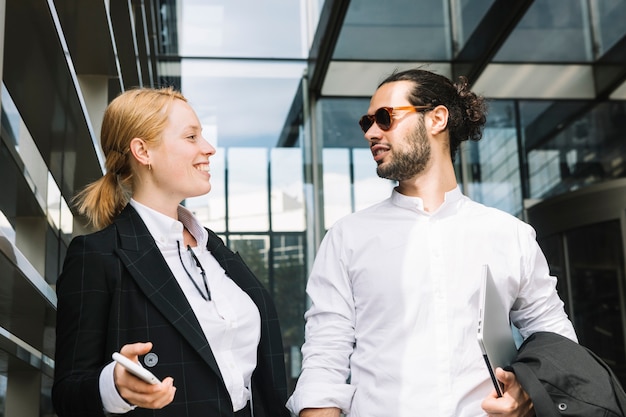 Happy business people standing outside the office looking at each other