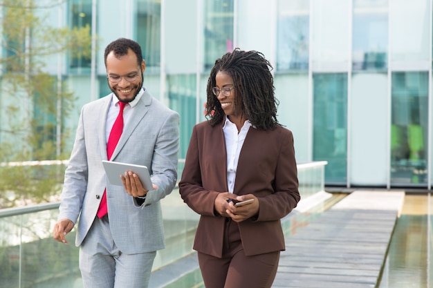 Happy business professional showing tablet screen