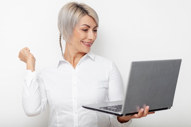 Happy business woman looking on laptop