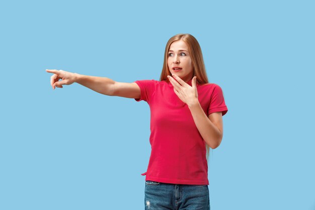 The happy business woman point you and want you, half length closeup portrait on blue wall