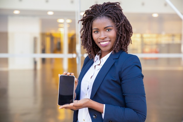Happy business woman presenting on cell screen