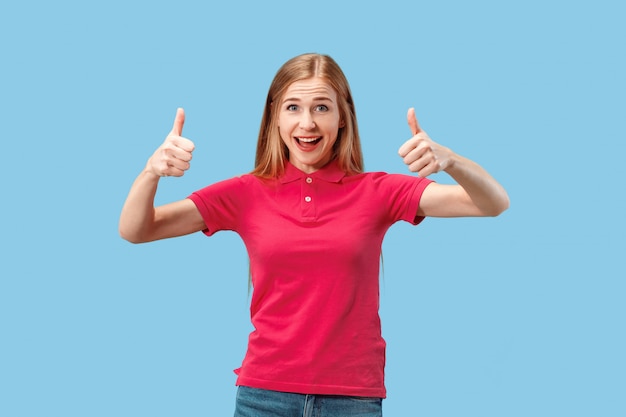 The happy business woman standing and smiling against blue space.