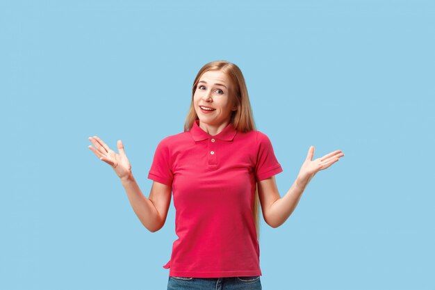 The happy business woman standing and smiling against blue wall