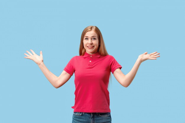 The happy business woman standing and smiling against blue wall