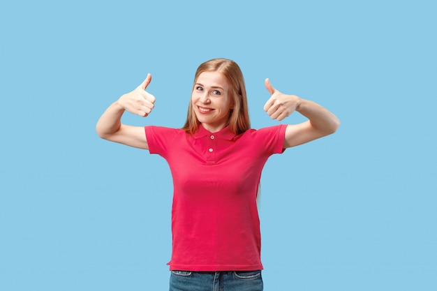 The happy business woman standing and smiling against blue wall