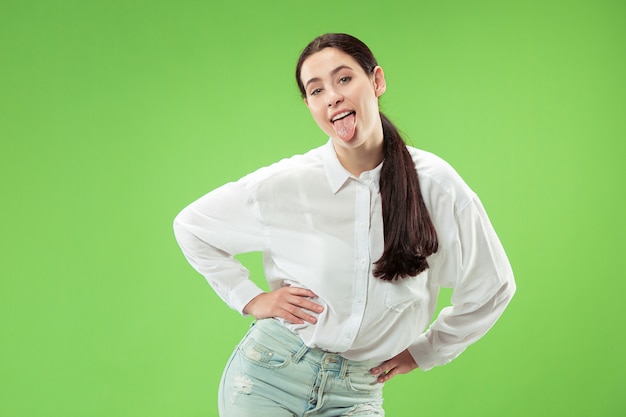 Happy business woman standing and smiling isolated on green studio background. Beautiful female half-length portrait. Young emotional woman. The human emotions, facial expression concept