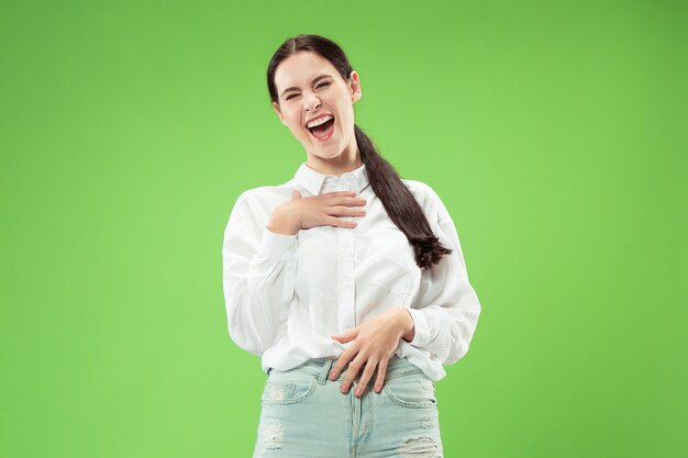 緑のスタジオの壁に孤立して立って笑顔幸せなビジネス女性