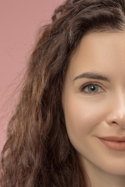 Happy business woman standing and smiling isolated on pink studio background. Beautiful female half face portrait. Young emotional woman. human emotions, facial expression concept. Front view.