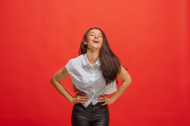 Happy business woman standing and smiling isolated on red. Beautiful female half-length portrait.