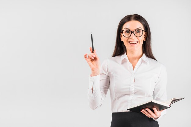 Happy business woman standing with notebook 