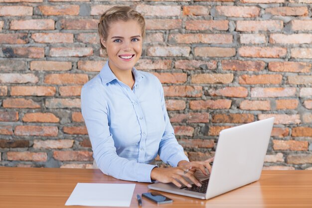 Happy Business Woman Working on Laptop at Desk